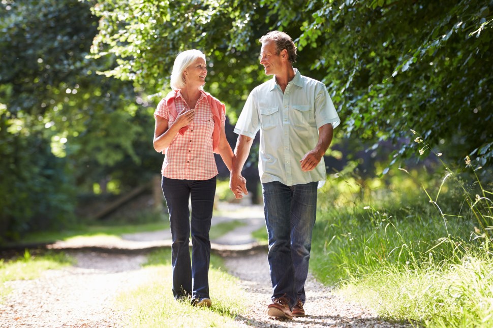 Romantic Middle Aged Couple Walking Along Countryside Path